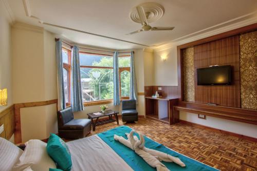 Una habitación de hotel con una cama con una toalla. en Woodstock Inn Manali en Manāli
