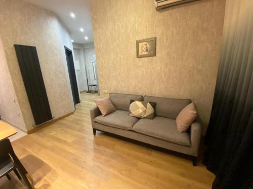 a living room with a couch with pillows on it at Villa Residence Apartment in Tbilisi City