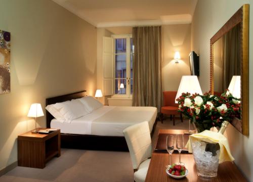 a hotel room with a bed and a table at Sina Maria Luigia in Parma