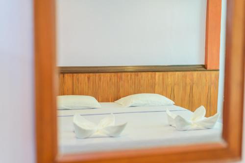 a bed with two white pillows in a room at หาดตื้น คลื่นสวย รีสอร์ท - Hadtuen Kluensuay Resort in Chao Lao Beach