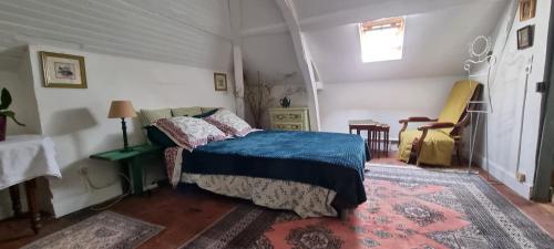 a bedroom with a bed with a blue blanket at Chambre d'Hôtes Les Jardins de Marie, SCI Charles III in Bernay