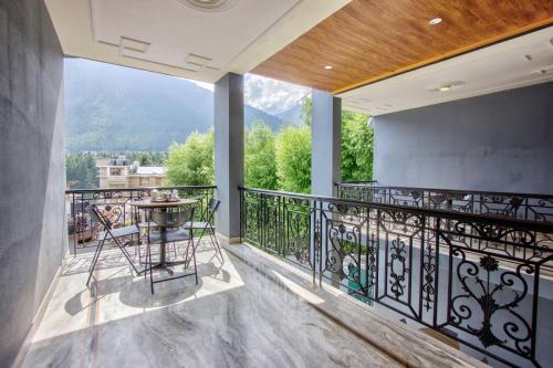 a balcony with a table and chairs on it at Woodstock Inn Manali in Manāli