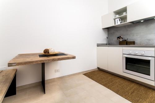 a kitchen with a wooden table and a counter at Mercatovecchio Luxury Suites in Udine