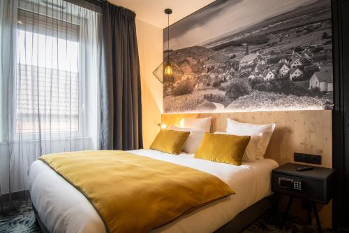 a hotel room with a bed and a large window at L' Hôtel & Spa Ribeauville- Haut-Koenigsbourg in Ribeauvillé