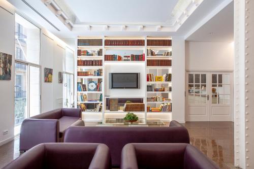 a living room with two purple couches and a tv at Gaudi Hotel in Barcelona