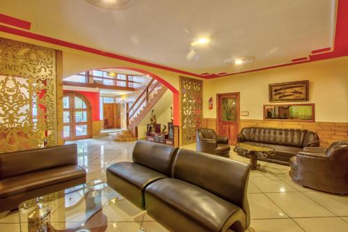 a living room with leather couches and a lobby at Woodstock Inn Manali in Manāli