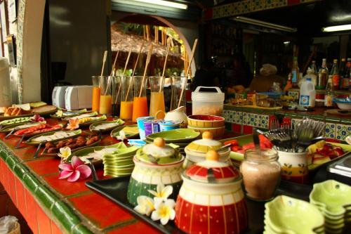 a buffet line with plates and bowls of food at Secret Garden Chiangmai in San Kamphaeng