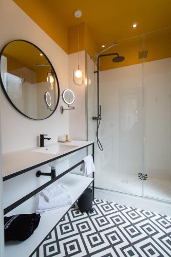 a bathroom with a sink and a shower at L' Hôtel & Spa Ribeauville- Haut-Koenigsbourg in Ribeauvillé