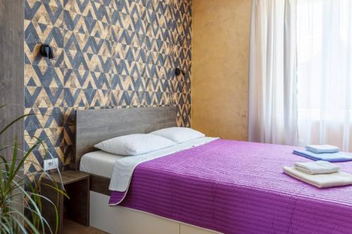 a bedroom with a bed with a purple blanket at Apartments NANA in Golubac