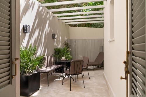 un patio con mesa, sillas y pérgola en Kinglin Luxury Living, en Atenas