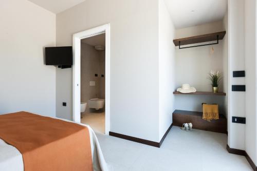 a bedroom with a bed and a room with a toilet at Agriturismo La Vista - Adults Only in Fonteblanda