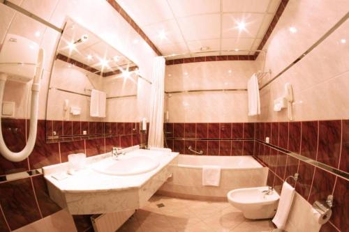Parkhotel Vienna في بييلسكو بياوا: حمام مع حوض وحوض استحمام ومرحاض