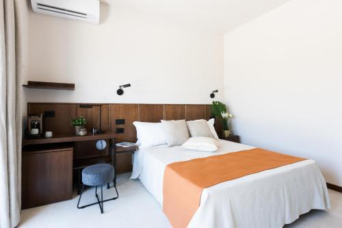 a bedroom with a bed and a desk and a chair at Agriturismo La Vista - Adults Only in Fonteblanda