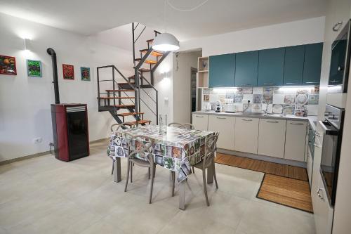 a kitchen with a table and a spiral staircase at Ca' de Paggia in Savona