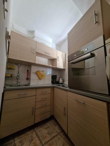 a kitchen with wooden cabinets and a stove top oven at Apartment Dada in Pula