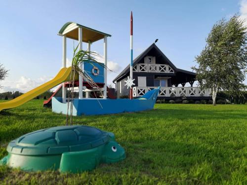 a playground in front of a house with a slide at Domek Lawendowe Wzgórze in Mielenko