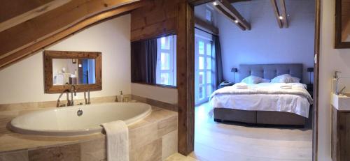 ein Badezimmer mit einer Badewanne neben einem Bett in der Unterkunft Chalet M in Grindelwald