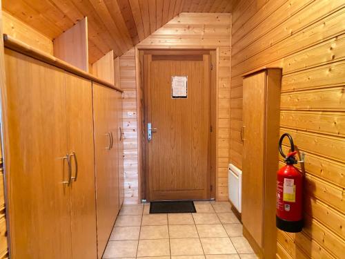 een hal met een deur en een brandblusser bij Chalet Sapin in Gérardmer