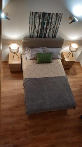 a bedroom with a bed with a green pillow and two lamps at Pátio do Marquês - estadias de curta e média duração in Portalegre