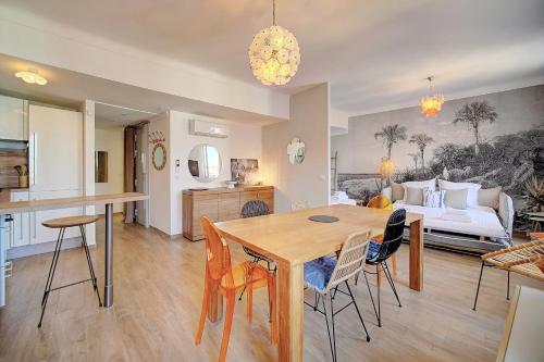 une cuisine et un salon avec une table et des chaises dans l'établissement IMMOGROOM - Sea view apartment - 3 min from beach - AC, à Cannes