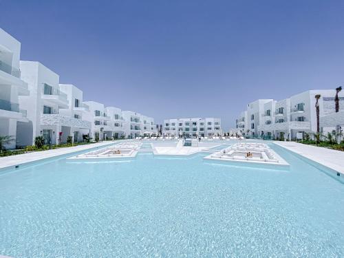 a large swimming pool in front of a large building at Tanoak Resort in Ain Sokhna