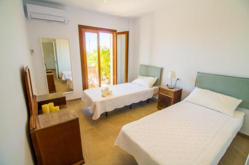 a bedroom with two beds and a mirror at Chez Margaux, fantástico apartamento in Port de Pollensa
