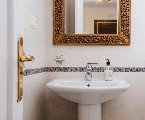 y baño con lavabo y espejo. en Apartamentos LÓRIEN Milladoiro, en Milladoiro