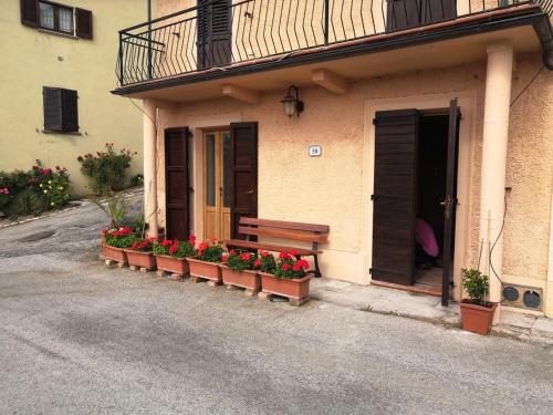 a bench sitting outside of a building with flowers at Casa Giorgio Mille Papaveri Rossi in Cesi