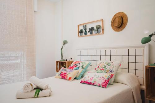 Un dormitorio con una cama con almohadas. en Apartamentos LÓRIEN Milladoiro, en Milladoiro