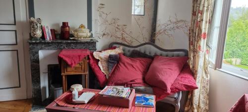 a living room with a couch with red pillows at Chambre d'Hôtes Les Jardins de Marie, SCI Charles III in Bernay
