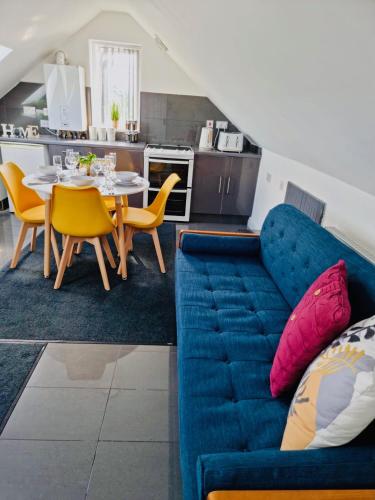 a living room with a blue couch and a table at Cosy 3 Bed Apartment Near Birmingham Airport & NEC Perfect for Groups & Contractors! in Birmingham