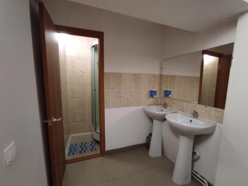 een badkamer met 2 wastafels, een bad en een douche bij Комплекс центр развития туризма in Zlato-oest