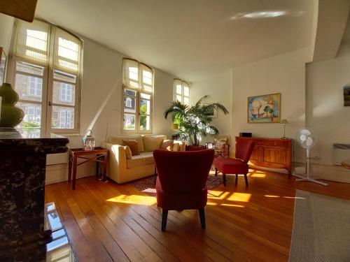 a living room with a couch and chairs at Beaune City Suite in Beaune