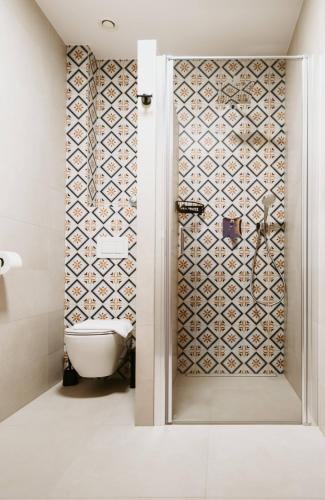a bathroom with a toilet and a shower with a tile wall at Pod humnama in Krumvíř