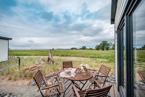 a patio with a table and chairs and a field at Marina Martinshafen in Sassnitz