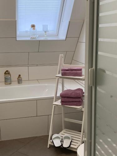 a bathroom with a towel rack next to a bath tub at FeWo Casa in Boizenburg