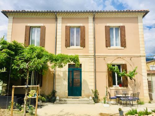 a house with a blue door and a table at La maison Gerval in Bédoin