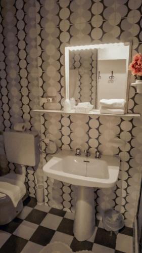 a bathroom with a sink and a mirror at Le Coeur du Pont in Donnas