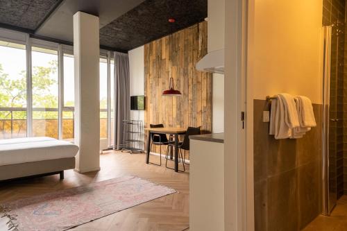 a living room with a bed and a dining room at Guesthouse Vertoef in Nijmegen