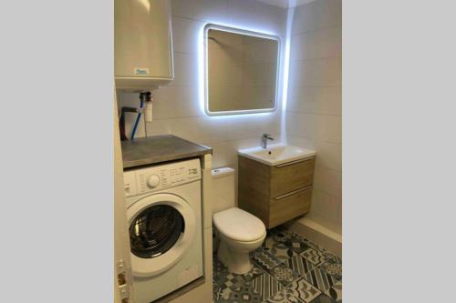 une salle de bain avec une machine à laver et un lavabo dans l'établissement Studio à 50 m de la mer avec parking privatif, à Saint-Hilaire-de-Riez