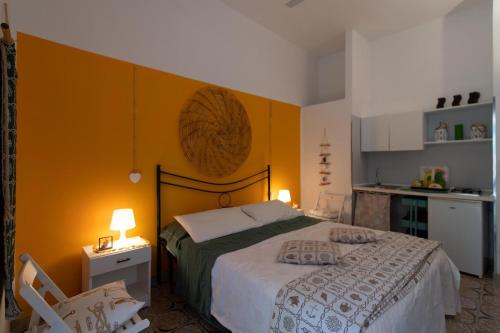 a bedroom with a bed with an orange wall at Gariga Holidays Apartments in Nardò