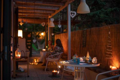 a woman sitting at a table in a restaurant at night at Gariga Holidays Apartments in Nardò