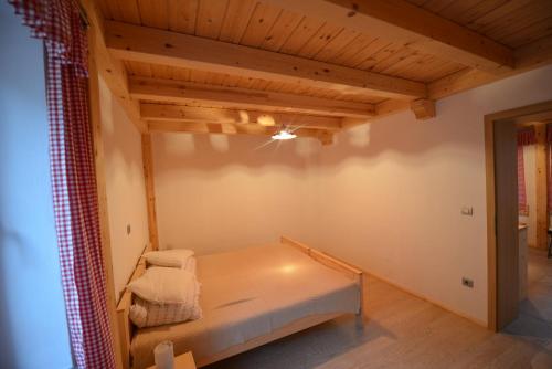 Zimmer mit einem Bett und einer Holzdecke in der Unterkunft Apartments Mojca in Bled