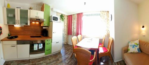 eine kleine Küche und ein Esszimmer mit einem Tisch in der Unterkunft Oberreiter's Alpennest in Fusch an der Glocknerstraße