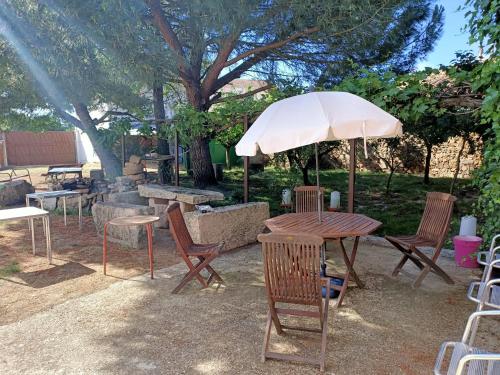 a table and chairs with an umbrella in a park at Casa Rural Arribes Vida I in Vitigudino
