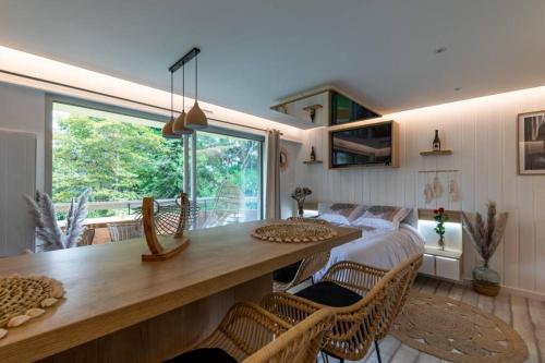 une chambre avec un lit, une table et des chaises dans l'établissement LE QUINTESSENCE: Balnéo & Luminothérapie + parking, à Voiron