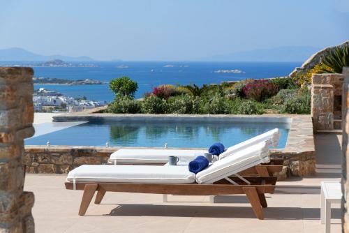 two beds on a patio with a swimming pool at Naxos Rock Villas in Stelida
