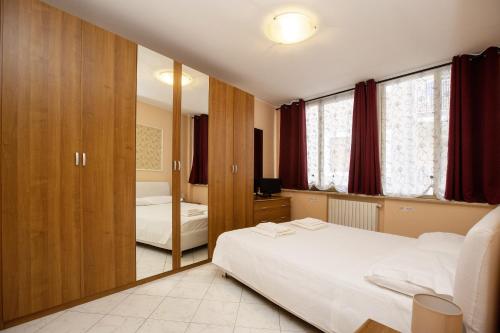 1 dormitorio con 2 camas y espejo en Casa Fabrizia, en Desenzano del Garda