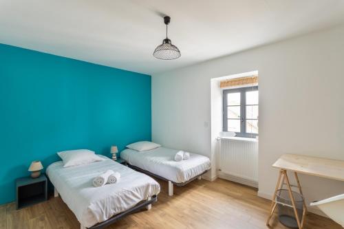 a room with two beds and a blue wall at Le Ty Family in Dinard
