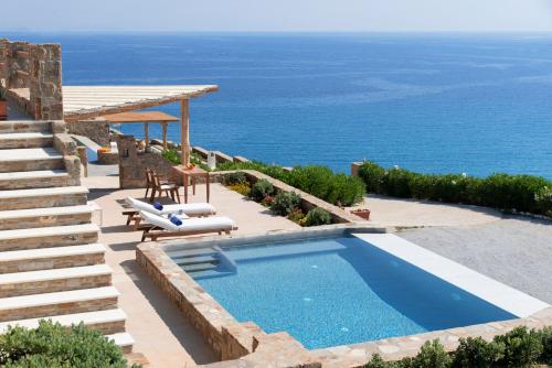 a swimming pool with a view of the ocean at Naxos Rock Villas in Stelida